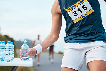 Image showing Hand, water and running a marathon race for competition closeup with fitness or cardio on a street. Sports, exercise or health and a runner or athlete person with a drink while on a road for training