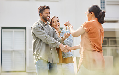 Image showing House key, realtor woman and handshake with couple outdoor as congratulations, thank you or sale. Excited man, partner and shake hands with real estate agent for new home, mortgage or future property