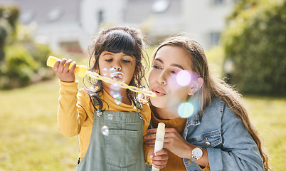 Image showing Mother and girl child blowing bubbles together on grass in nature for picnic, happiness and love. Summer, woman and kid in park or playground for family play, freedom and quality time with care