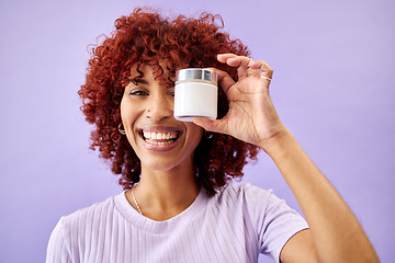 Image showing Portrait, beauty and cream for skincare with a woman holding a container in studio on a purple background. Face, smile and promotion of a product or serum for antiaging with a happy young model