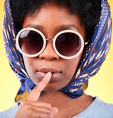 Image showing Fashion, silence and sunglasses with portrait of black woman in studio for vintage, secret and beauty. Mystery, whisper and rumor with person and scarf on yellow background for frames and style