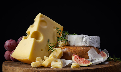 Image showing still life with cheese on wooden cutting board