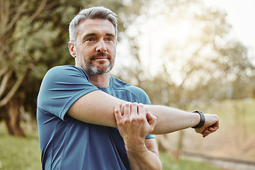 Image showing Mature man, arm stretching and outdoor for fitness, wellness and exercise in a park for health. Morning, athlete and training in nature with workout and sports of a calm person ready to start run