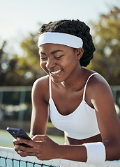 Image showing Tennis, black woman smile and phone text outdoor for sport, fitness and workout with social media at net. Exercise, match training and mobile networking with website and app on court for wellness