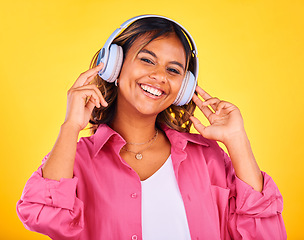 Image showing Woman, headphones and listen to music in portrait, happiness and entertainment on yellow background, Fun, audio streaming and radio with rave or techno in studio, student with wireless tech and smile