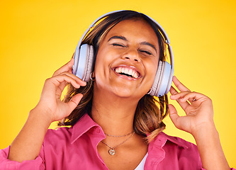 Image showing Headphones, excited and young woman in a studio listening to music, playlist or radio for entertainment. Happy, technology and female model from Mexico streaming a song or album by yellow background.