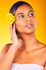 Image showing Skincare, flower and young woman in studio with cosmetic, glow and beauty face routine. Dermatology, floral rose and female model from Mexico with facial skin treatment isolated by yellow background.