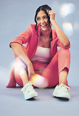 Image showing Woman, fashion and thinking with gen z style and smile and sitting in studio. Trendy, stylish clothing and happy female person with freedom, funky outfit and modern clothes with blue background