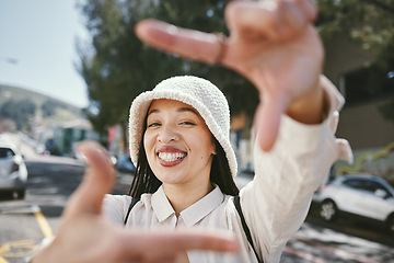 Image showing Happy woman, portrait and frame in city for photography, fashion or outdoor memory in selfie. Female person smile with hands framing face for photograph, picture or social media tour in urban town