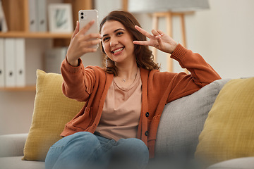 Image showing Selfie, peace hand sign and woman on couch, social media post with influencer at home and memory. Smile in picture for content creation, mobile app and relax in living room, V emoji and photography