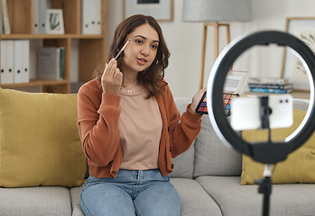 Image showing Social media, makeup and tutorial with a woman influencer in her home to broadcast live content to viewers. Streaming, product or review with a young brand ambassador in the living room for cosmetics