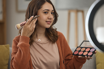 Image showing Streaming, makeup and tutorial with a woman influencer in her home to broadcast live content to viewers. Social media, product or review with a young brand ambassador in the living room for cosmetics