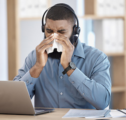 Image showing Black man, sick and call center blowing nose with tissue, allergy or flu in customer service at office. African male person, consultant or agent with cold, symptoms or immune virus at workplace