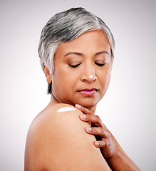 Image showing Skin cream, shoulder and beauty of a mature woman with natural glow on a white background. Dermatology, moisturizer and cosmetics of aesthetic model for body shine, wellness or self care in studio
