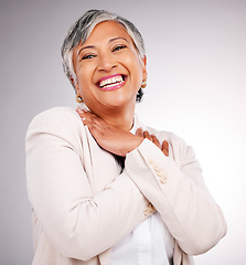 Image showing Portrait, happy and a mature business woman laughing in studio on a gray background for executive or growth. Comic, smile and face frame with a corporate professional looking confident in a suit