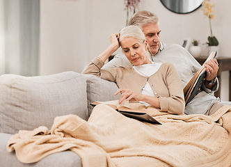 Image showing Old couple on couch, reading book and relax together at home, retirement and wellness with love and comfort. Trust, care and support in marriage, share hobby with partner for knowledge and story