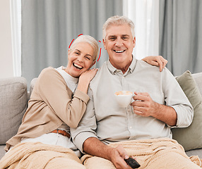 Image showing Senior couple, watching tv and laughing on a living room sofa with tea and movie at home. Elderly people, bonding and marriage in retirement with series and streaming in a lounge on a couch together