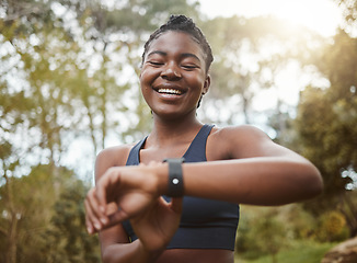 Image showing African runner woman, smart watch and park for check, smile or happy for time, results or fitness in nature. Girl, iot clock and monitor for speed, heart rate or smile for exercise, workout or health