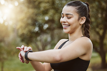 Image showing Happy runner woman, smart watch and park for check, smile or reading for time, results or fitness in nature. Girl, iot clock and monitor for speed, heart rate or smile for exercise, workout or health