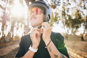 Image showing Cycling, fitness and man with helmet check, in forest with safety for extreme sports in nature. Mountain bike, face and guy cyclist gear tie in park for off road hobby, freedom or adrenaline workout