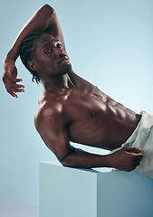 Image showing Black man, beauty with grooming and fitness, shirtless in studio in portrait on blue background. Hygiene, skincare and African model with muscle, clean dermatology and natural cosmetics for wellness