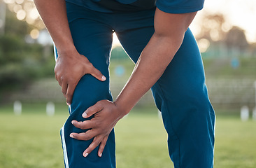 Image showing Sports, injury and person on field with knee pain for accident, emergency and joint ache for muscle sprain. Fitness, healthcare and hands of athlete with strain from exercise, workout and training