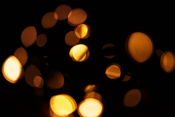 Image showing Gold, bokeh and light in a studio with a dark background for celebration, event or party. Mockup, sparkle and yellow for glow, magic or shine for festive decoration by a black backdrop with mock up.