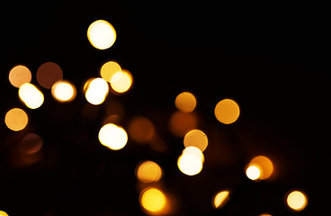 Image showing Gold, bokeh and light in a studio with a dark background for celebration, event or party. Mockup, confetti and yellow for glow, magic or shine for festive decoration by a black backdrop with mock up.