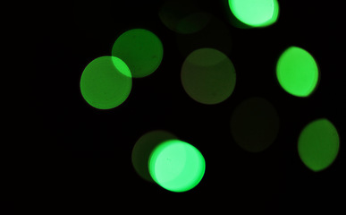 Image showing Green, bokeh and light in a studio with a dark background for celebration, event or party. Mockup, sparkle and color for glow, magic or shine for festive decoration by a black backdrop with mock up.