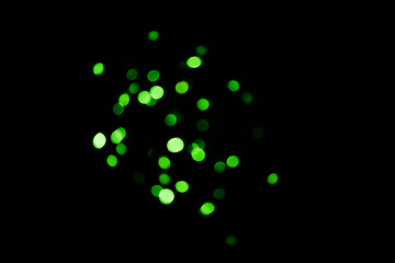 Image showing Green, lights and bokeh in a studio with dark background for celebration, event or party. Confetti, glitter and color sparkles for magic, shine or glow for festive by black backdrop with mockup.