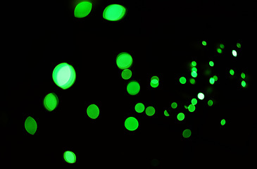 Image showing Green light, bokeh and glow on dark background isolated on a mockup space. Blur, black backdrop and defocused shine, sparkle or glitter at night for Christmas, holiday or party with magic color dots