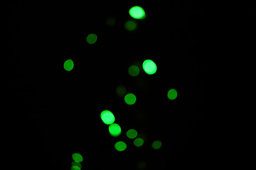 Image showing Green light, bokeh and dots on dark background on a mockup space. Blur, black backdrop and defocused shine, sparkle or glitter glow at night for Christmas, holiday or party with magic color wallpaper