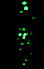 Image showing Bokeh, green dots and light on black background with pattern, texture and mockup with cosmic aesthetic. Night lighting, sparkle particles and glow on dark wallpaper with space, color shine and flare.