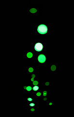 Image showing Bokeh, neon green lights on black background and dots with pattern, texture and mockup with cosmic aesthetic. Night lighting, sparkle particles and glow on dark wallpaper with space, shine and flare.