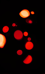 Image showing Bokeh, red and orange lights on dark wallpaper with pattern, texture and mockup with cosmic aesthetic. Night lighting, sparkle particles and glow on black background with space, color shine and flare