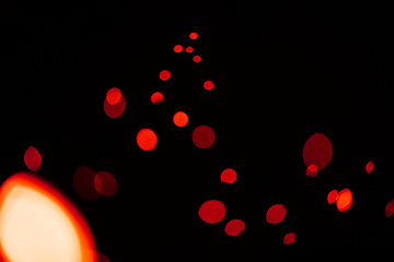 Image showing Red, glitter and bokeh in a studio with dark background for celebration, event or party. Confetti, lights and color sparkles for magic, shine or glow for festive by black backdrop with mockup.