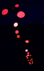 Image showing Bokeh, red lamp lights on black background with pattern, texture and dots mockup with cosmic aesthetic. Night lighting, sparkle particles and glow on dark wallpaper with space, color shine and flare.