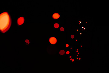 Image showing Bokeh, red lights and dark wallpaper with pattern, texture and mockup with cosmic dots aesthetic. Night lighting, sparkle particles and glow on black background with space, color shine and flare.