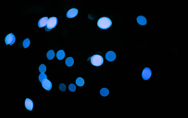 Image showing Blue, confetti and bokeh in a studio with dark background for celebration, event or party. Lights, glitter and color sparkles for magic, shine or glow for festive by black backdrop with mockup.