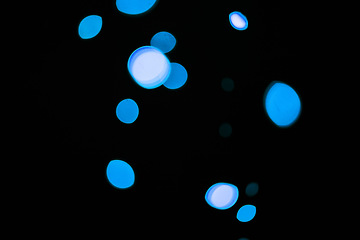 Image showing Bokeh, blue particles and dots on dark background with pattern, texture and mockup with cosmic aesthetic. Night lighting, sparkle lights and glow on black wallpaper with space, color shine and flare.