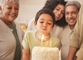 Image showing Birthday party, happy family and child with cake blowing candle in a home for event to celebrate together in a house. Grandparents, happiness and kid excited for gathering, surprise and gift