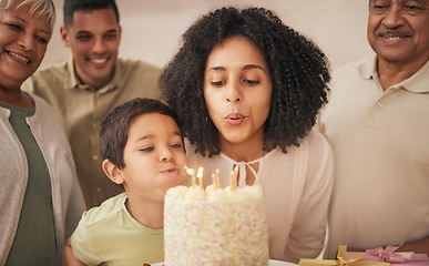 Image showing Happy birthday, big family and child with cake blowing candle in a home for event to celebrate together in a house. Grandparents, happiness and kid excited for gathering, surprise and gift