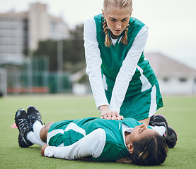 Image showing First aid, cpr and emergency with a hockey player on a field to save a player on her team after an accident. Fitness, training and heart attack with a woman helping her friend on a field of grass