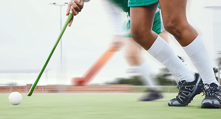 Image showing Person, feet and hockey stick on field, ball with speed or motion for sports goal, training or professional game. Action, legs and turf with performance for outdoor competition, fitness and exercise