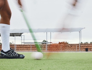 Image showing Person, legs and hockey stick on field, ball with speed or motion for sports goal, training or professional game. Action, feet and turf with performance for outdoor competition, fitness and exercise