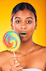 Image showing Shock, lollipop and portrait of woman in studio with makeup, cosmetic and face routine. Surprise, beauty and young Indian female model with colorful candy and facial cosmetology by yellow background.