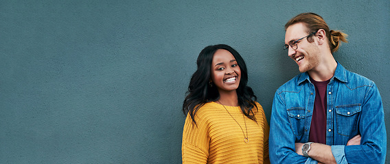 Image showing Happy, conversation and couple by wall with mockup space for advertising, promotion or marketing. Smile, talking and young interracial man and woman in discussion together by gray background mock up.