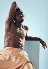 Image showing Muscle, art and black man with fitness, thinking and creativity on a blue studio background. African person, healthy guy and pose with model, beauty and wellness with fabric, artistic and aesthetic