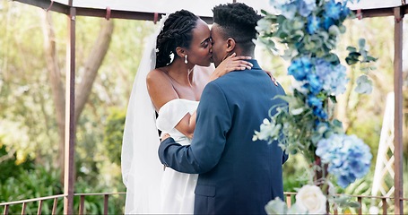 Image showing Black couple, wedding and kiss for love, marriage or commitment in embrace or hug together. Married African woman and man kissing affection, trust or relationship of bride or groom in outdoor romance