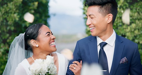 Image showing Couple, flower confetti and wedding event with walk, outdoor or happy laugh in nature. Woman, Asian man and excited for marriage, floral bouquet and love with care in park, party or together in aisle